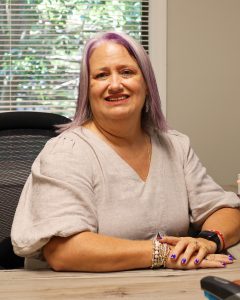 Financial advisor in her Aiken office smiling confidently while ready to discuss wealth management and retirement planning.