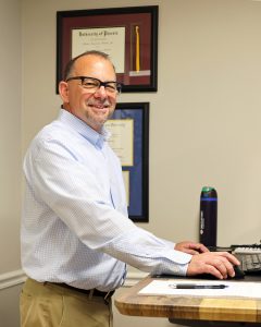 Financial advisor with credentials displayed in professional office setting ready to assist clients with wealth management.