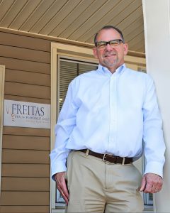 A financial advisor stands outside a medical office, representing Freitas Wealth Management's comprehensive insurance and.