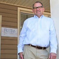 A financial advisor stands outside a medical office, representing Freitas Wealth Management's comprehensive insurance and.
